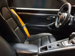 Interieur van een auto met gepersonaliseerde, gele gordels.