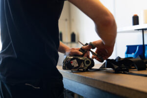 Medewerker van Autogordel.nl werkt aan het demonteren en vervangen van een autogordel op een werkbank.