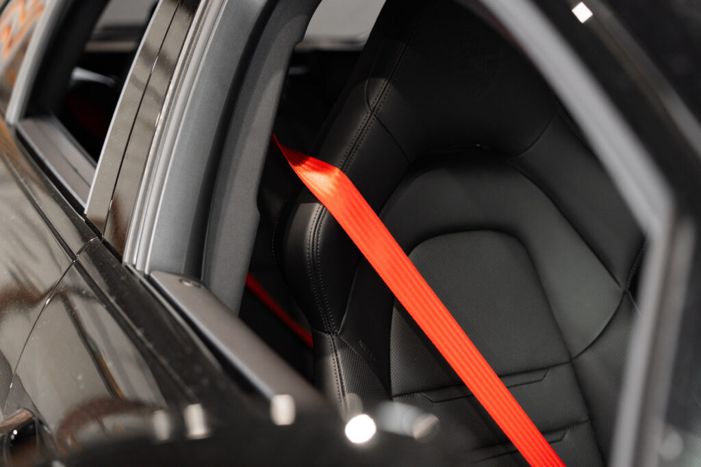 Felrode autogordel in luxe sportauto-interieur in de werkplaats van Autogordel.nl