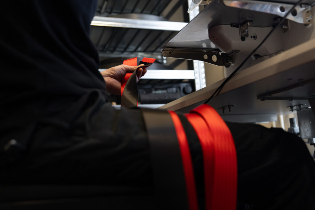 Rode autogordel wordt professioneel verwerkt en voorbereid voor montage in een auto.