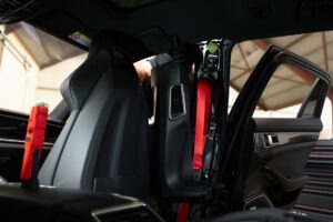 Rode autogordel gemonteerd in de B-stijl van een auto tijdens vervanging of installatie in de werkplaats.